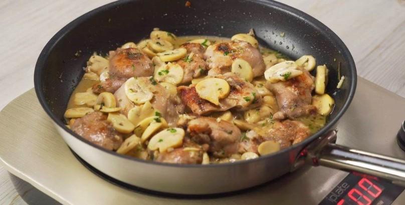 Курячі стегна з грибами та часником на сковороді