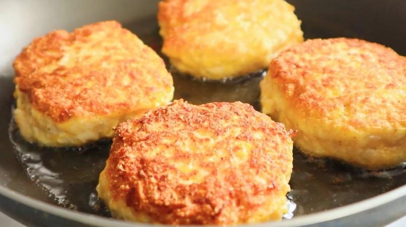 Яскраві курячі котлети з гарбузом на сковороді
