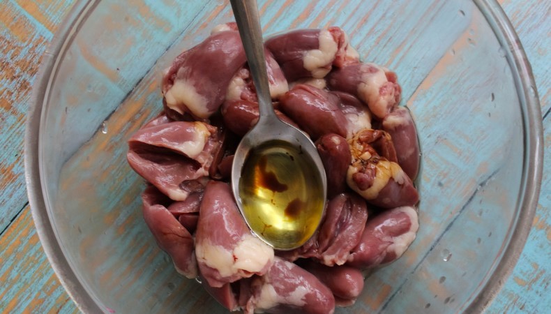Курячі серця на сковороді з цибулею та часником